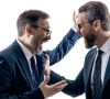 Zwei Männer in Anzug und Krawatte streiten wild gestikulierend