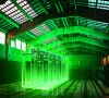 Lagerhalle mit einem leuchtend grünen 3D-Modell eines Wasserstoff-Elektrolyseurs