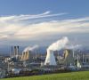rauchendes Kraftwerk an großem Industriestandort mit blauem Himmel