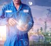 Schmuckbild Automatisierung, Person im Blauen Overall ruft digitale Informationen ab, Raffinerie im Hintergrund