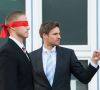 Mensch in Anzug und Krawatte schickt Mensch mit verbundenen Augen in eine unbekannte Richtung; Symbolbild für verbesserungsbedürftige Ausbildung
